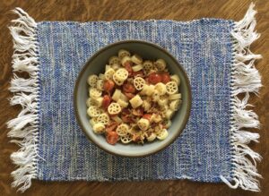 Pasta with roasted tomatoes in pottery bowl