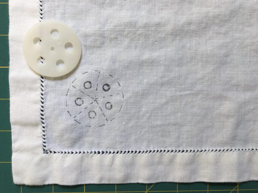 Circle embroidery pattern drawn on white linen napkin
