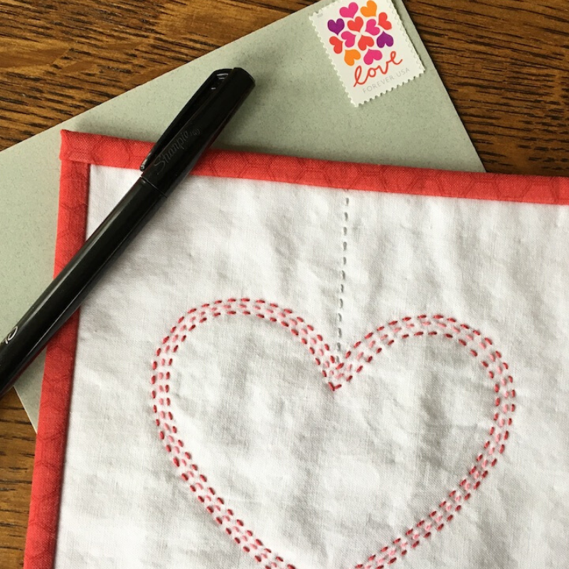 Completed Connected Hearts Mini Quilt with envelope and pen