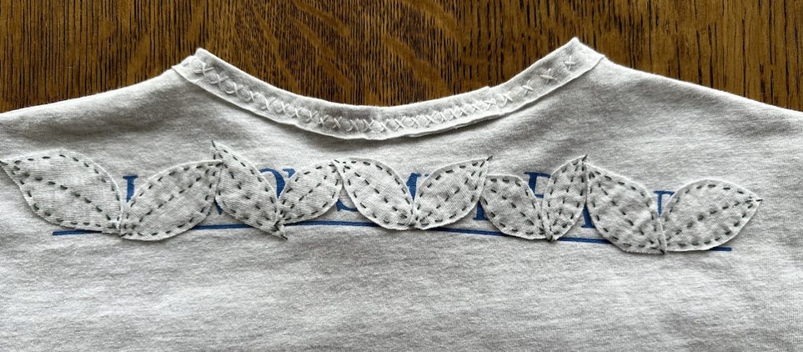 Up close image of leaves appliqued on gray t-shirt.